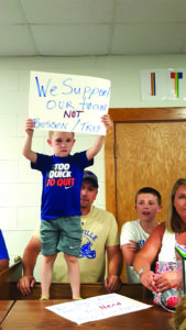 Landen Mackey held a poster during the special board meeting. Mackey's brothers Arin Mackey and Kaedin Saddlemire are both Granville football players. 